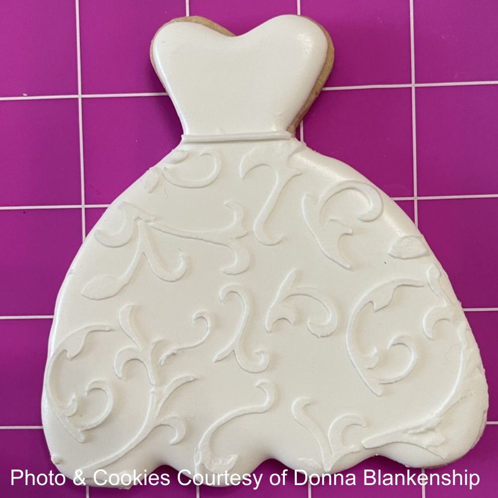 Scroll Pattern cookie stencil iced onto wedding dress cookie by Donna Blakenship