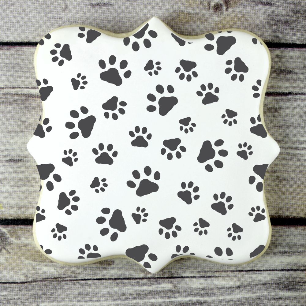 Mini Dog Paws Cookie Stencil shown on a royal iced cookie by Designer Stencils sample