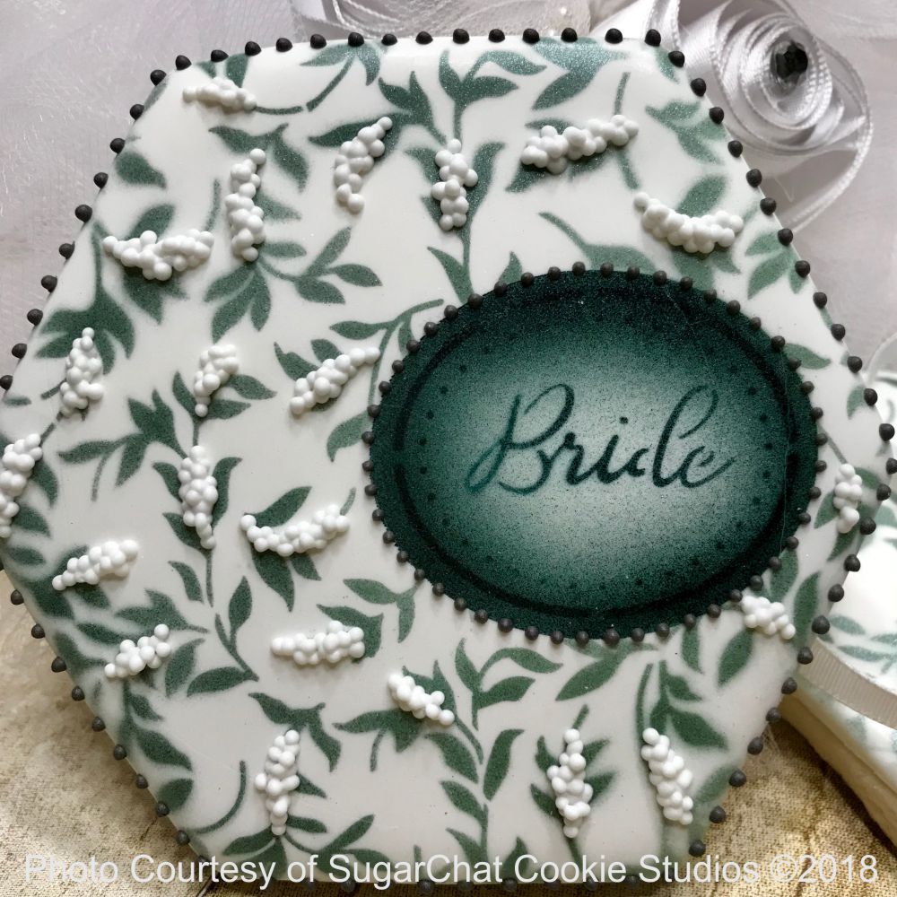 Beautifully stenciled cookie made our wedding cookie stencil or Bridal shower stencil. A flowered background with a framed text Bride dark on a light background
